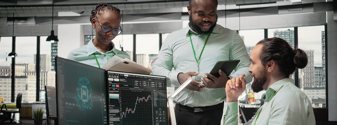 Team of professionals collaborating in an office, reviewing data and engineering solutions on digital screens.